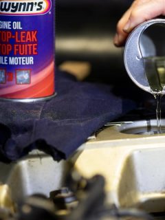 A hand pouring the additive inside the engine, Best Engine Oil Additives For Low Compression