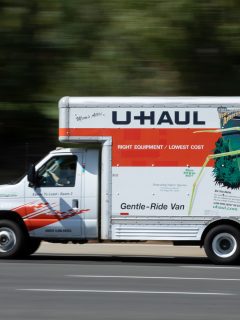 Light-shines-on-a-bright-white-and-orange-U-Haul-moving-truck.
