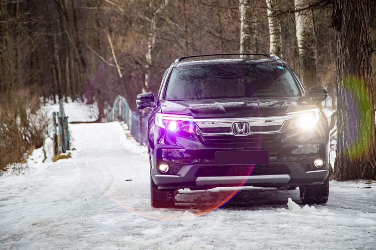New Honda SUV Pilot 3 Generation Black in winter off-road