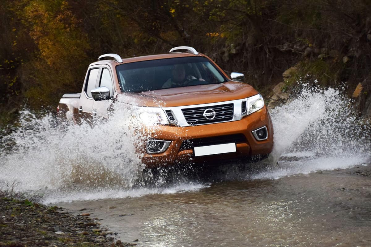 Nissan NP300 Navara driving by the river. This utility 4x4 vehicle was produced from 2015. The Navara is one of the most popular pickups in Europe.