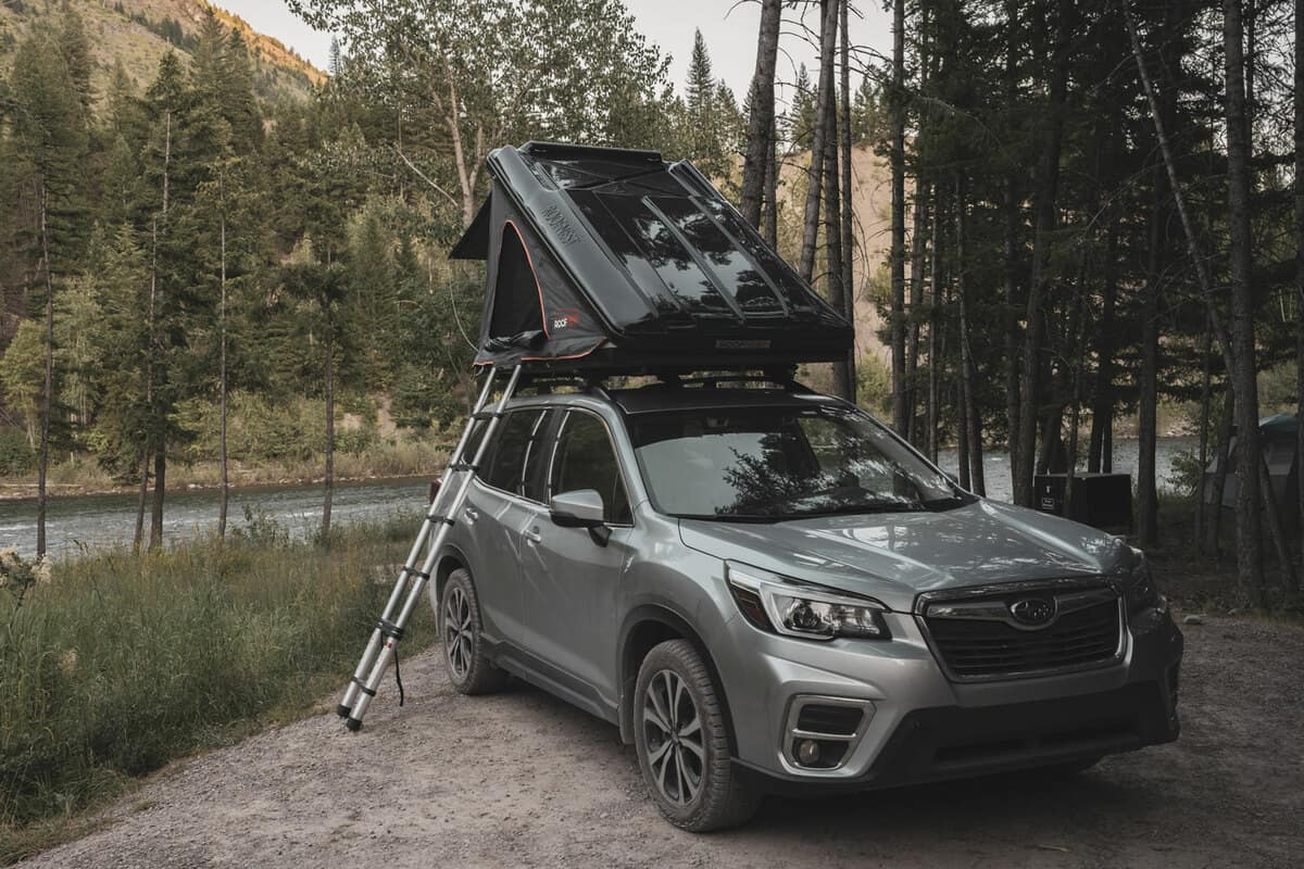 Setting up camp on top of a Subaru Forester parking close to a body of water