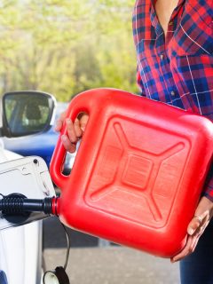 Woman with plastic gallon filling car tank, How Much Does A Gallon Of Gas Weigh?