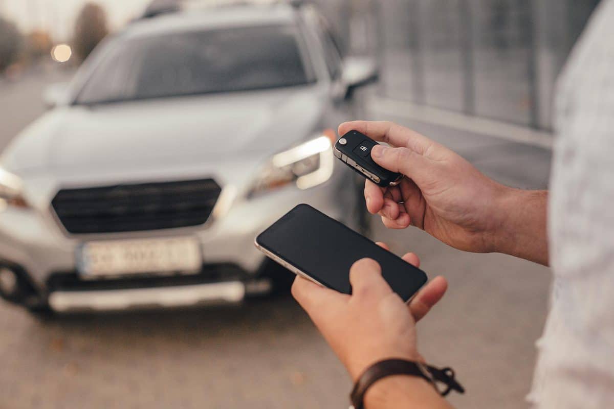 Young handsome man with smartphone and car keys
