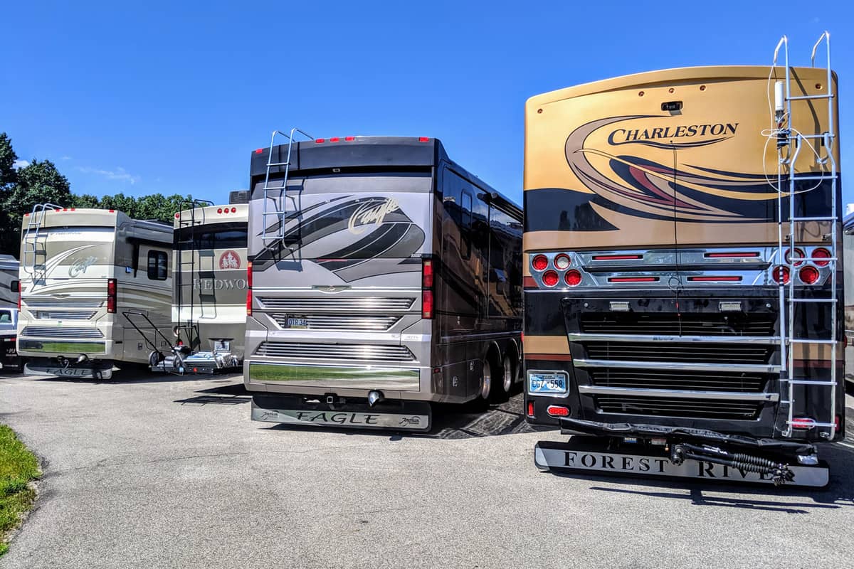 Several new large Class A rv motorhomes are parked together in a line