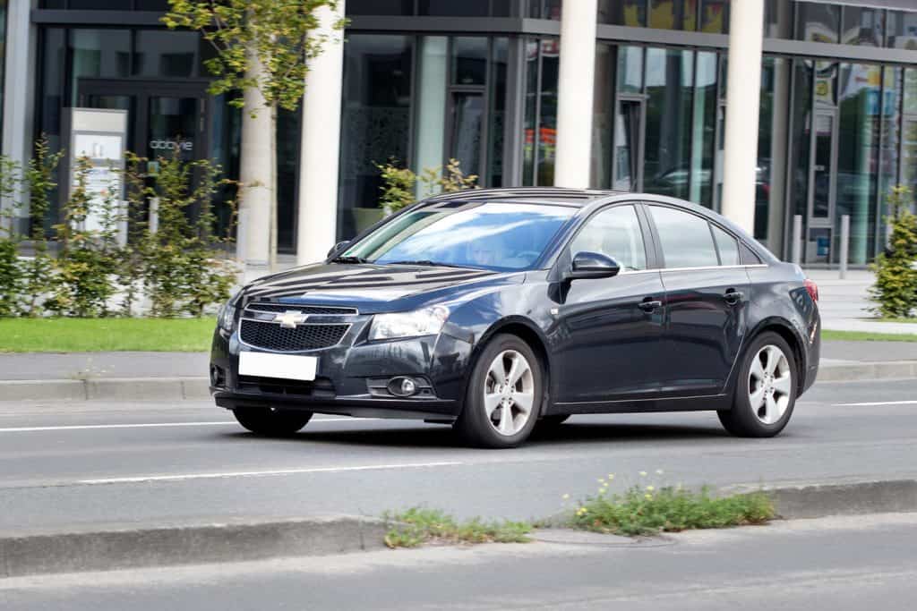  A couple in a dark Chevrolet Cruze in the city of Wiesbaden (Germany)