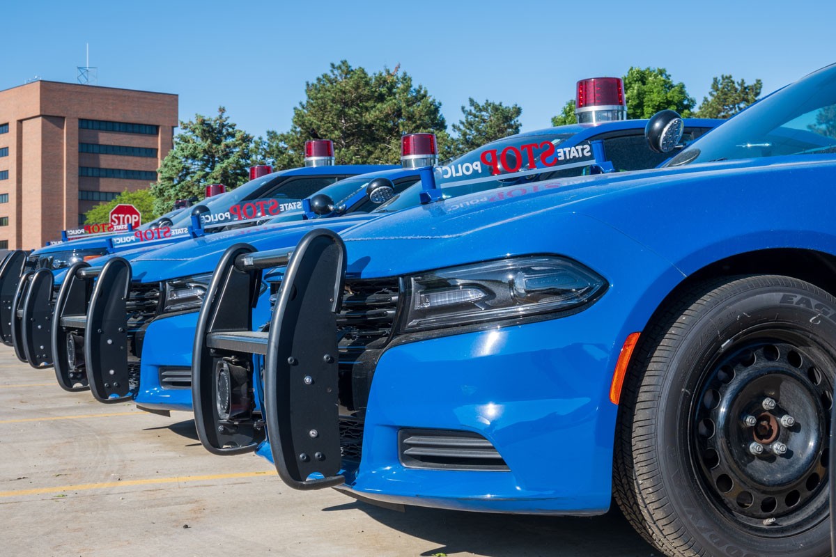 A line up of blue Police cars with metal bull bars