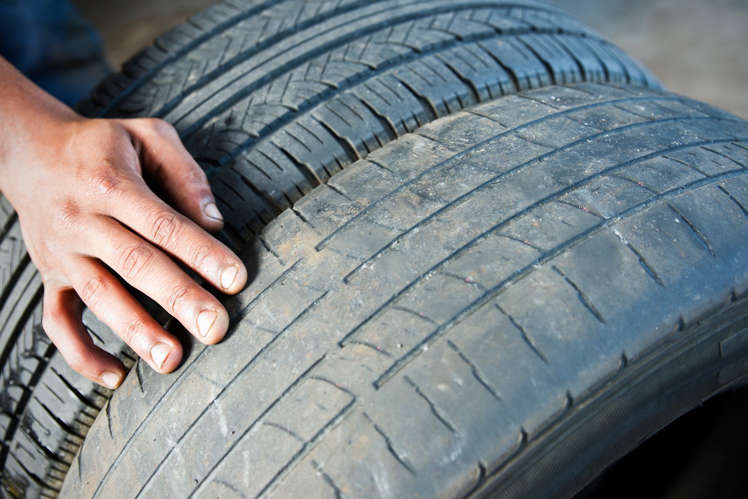 A photograph comparing a dangerously worn tire beside a newer tire with acceptable tread.