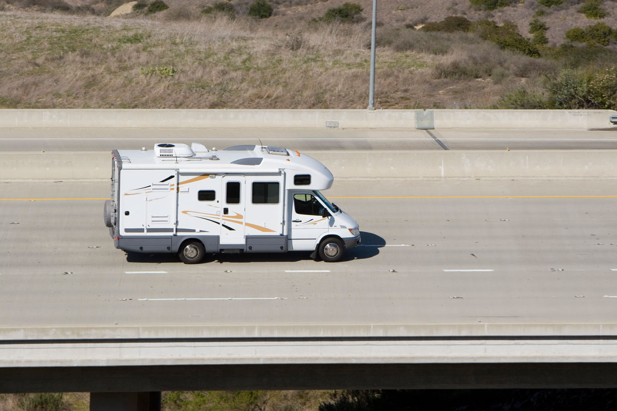 A white camper van moving on the expressway