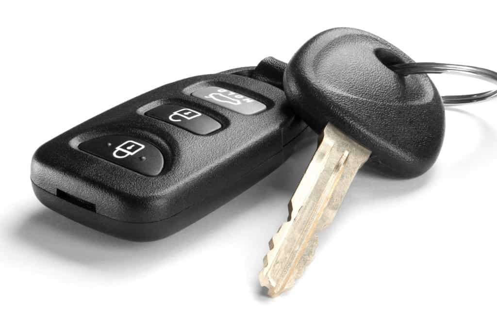 Black car key and remote on white background
