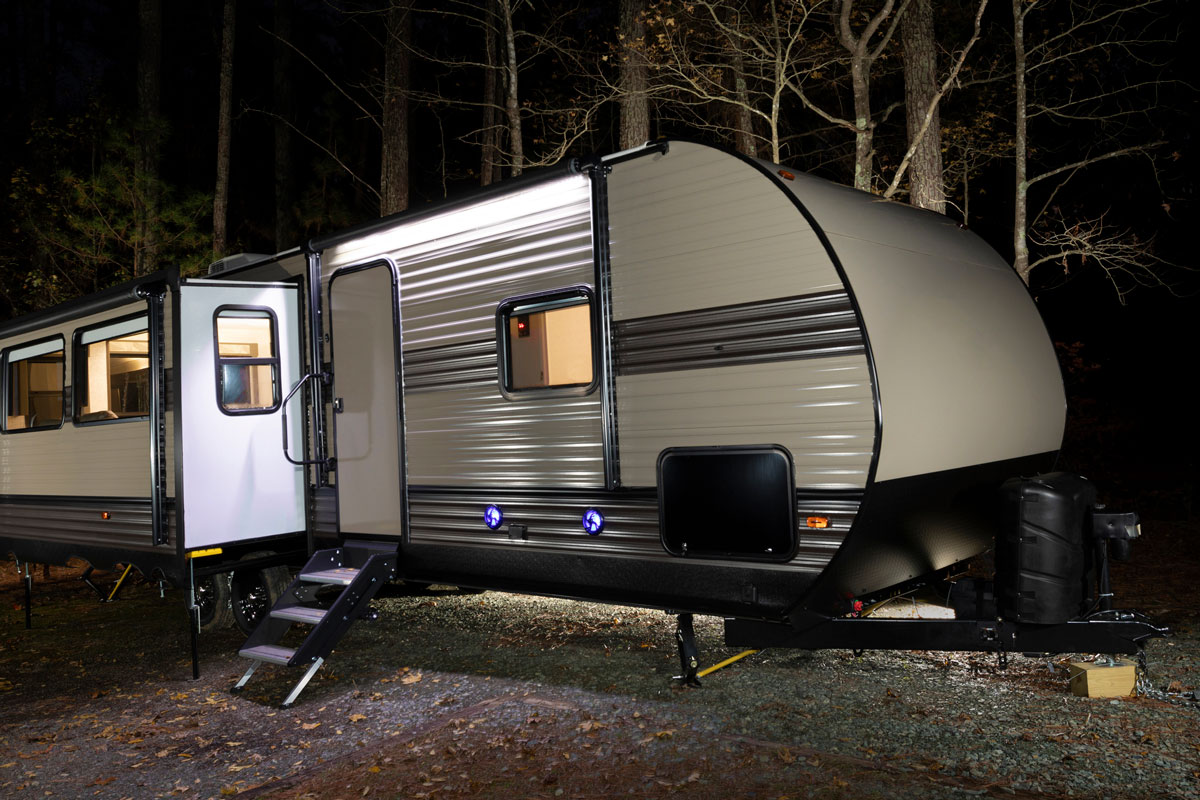 Camping trailer lighted at night with doors open