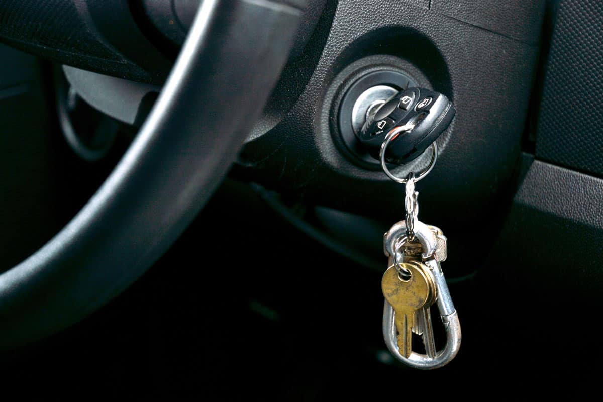 Car key and house key dangling from the ignition of car