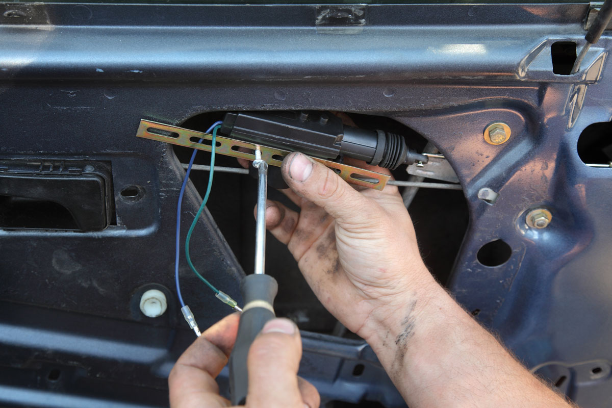 Car mechanic repairing or changing car door lock