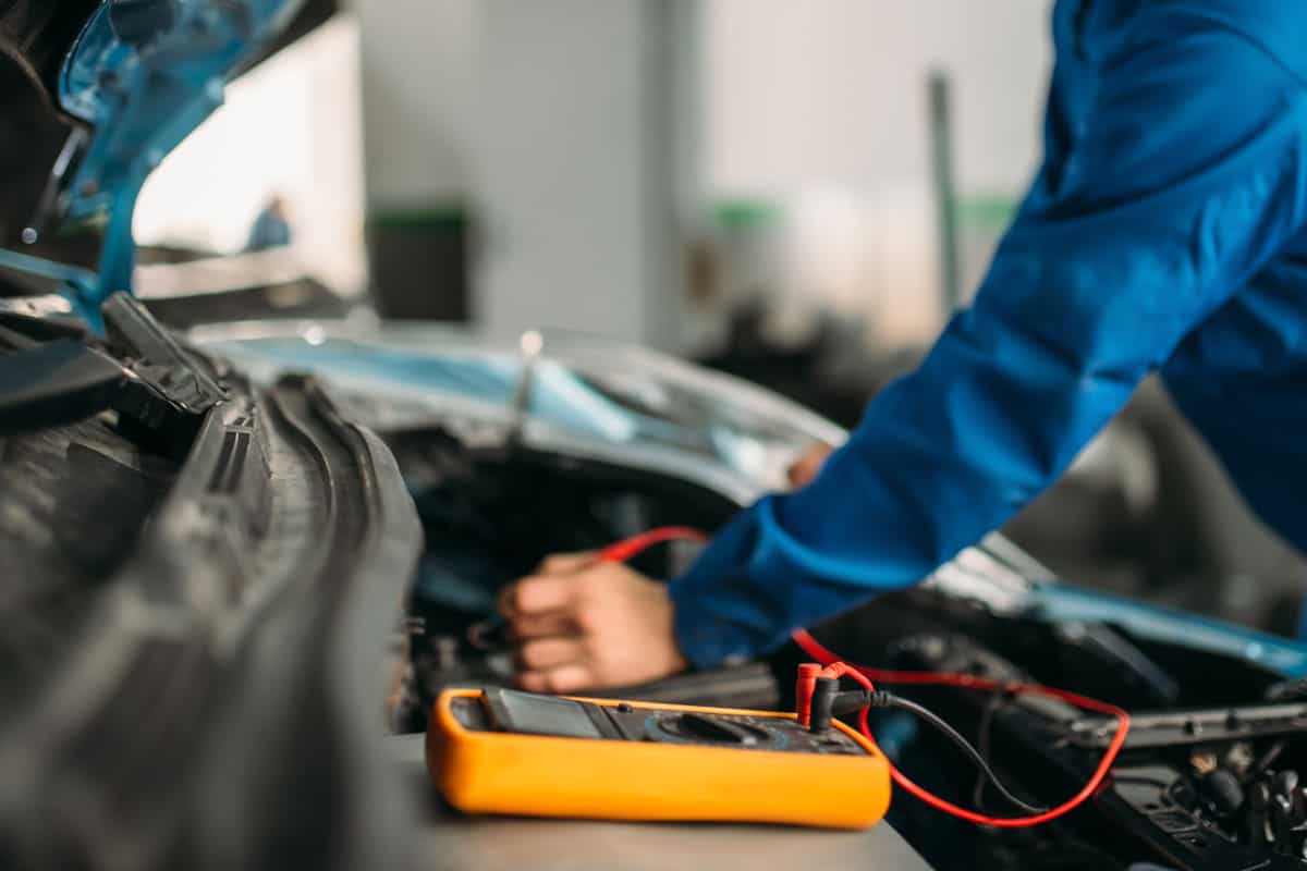 Car mechanic testing the car battery
