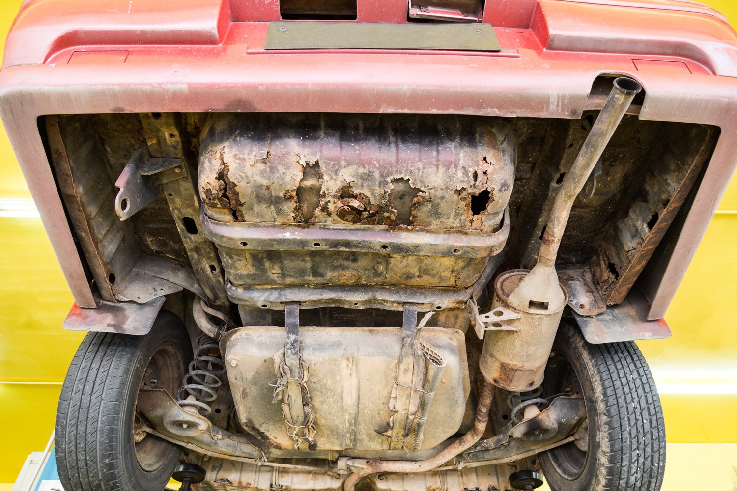 Car with rusty, damaged, corroded undercarriage at workshop for repair work