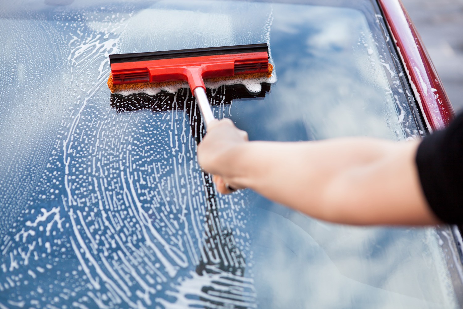 Close-up Of Hand Washing Car Window With Mop