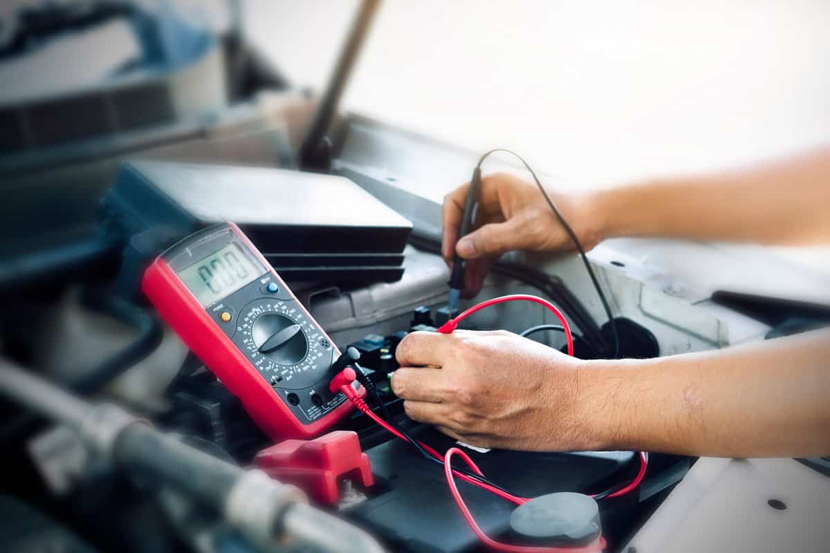 Close up of auto mechanic jumping battery car,check voltage level car battery.
