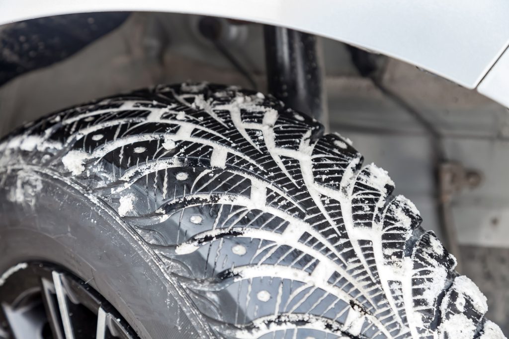 Close-up on a car wheel with tread Studded tires with little wear during filming for a safe birth in snow and ice.