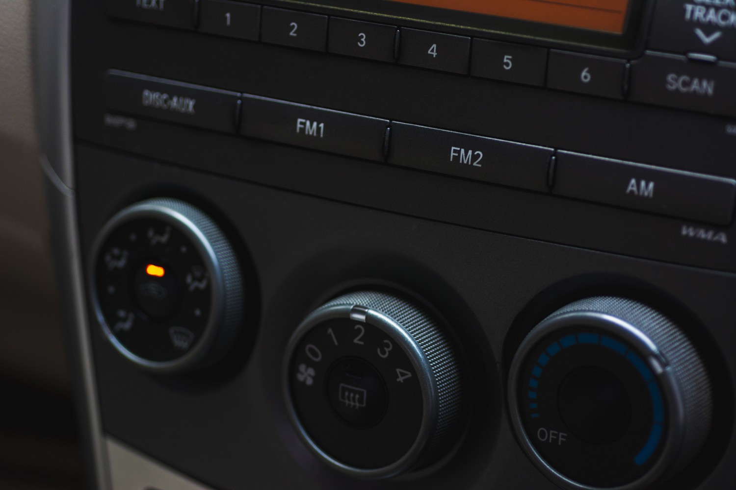 Closeup modern car radio receiver on natural blurred background.