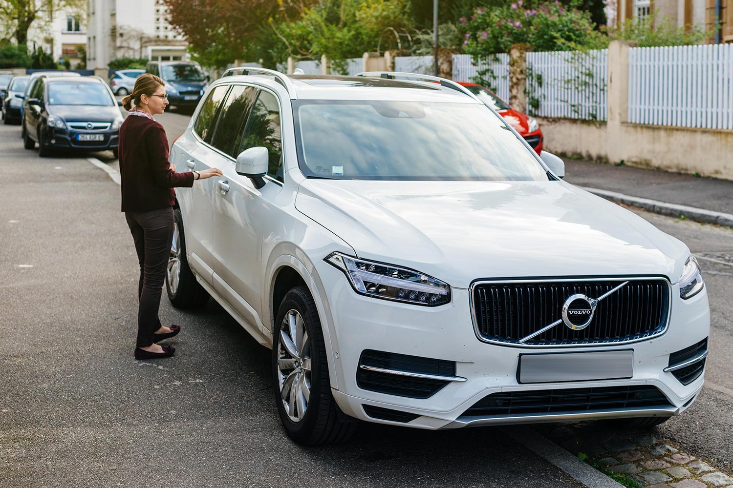 French woman aproaching her luxury white Volvo XC90