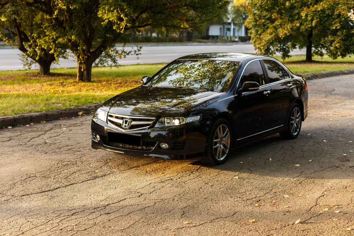 Honda Accord dark color on the walkway of Dnipro city street, autumn time