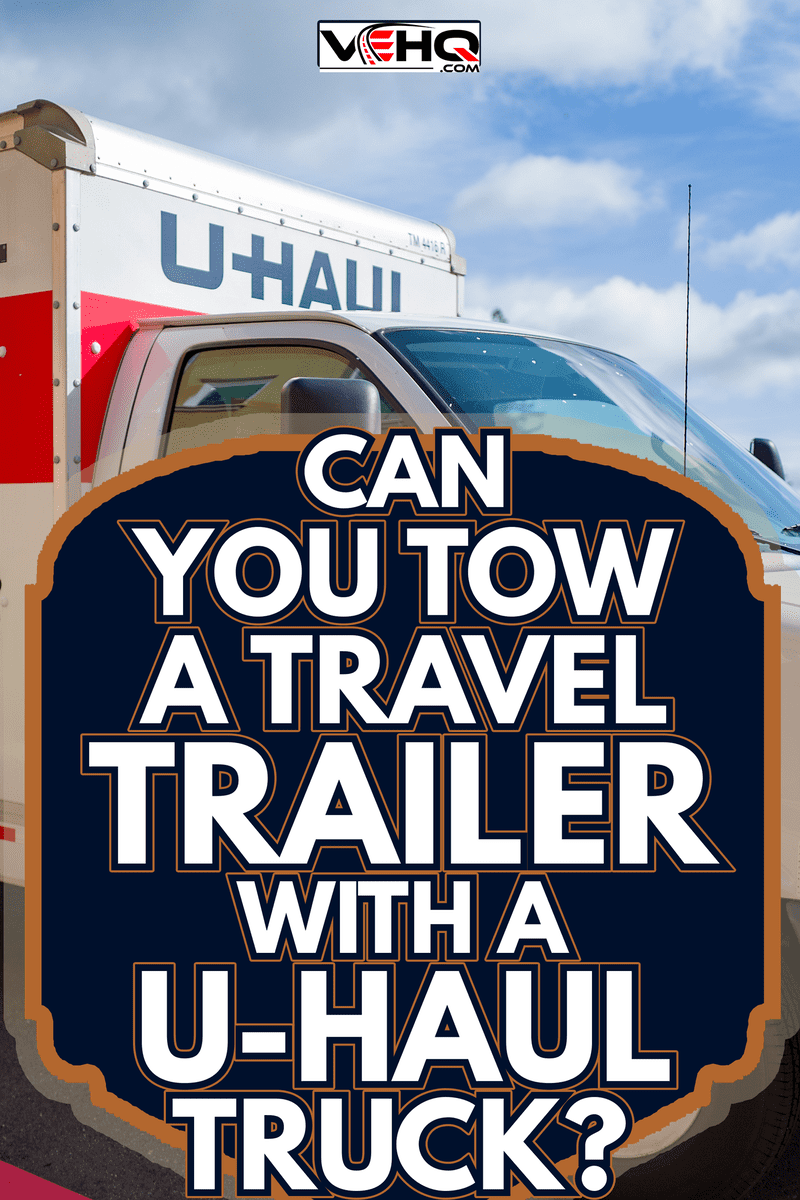 Light shines on a bright white and orange U-Haul moving truck - Can You Tow A Travel Trailer With A U-Haul Truck