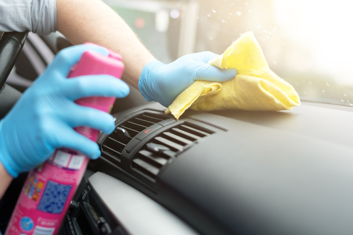 Man cleaning his car interiors and dashboard