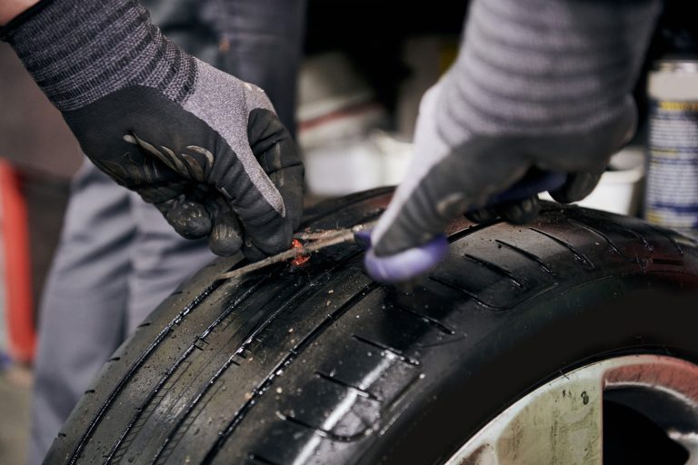 Mechanic Preparing the Nail Hole in a Punctured Tire by Cutting the Injection Moulding before Putting in the Crude Rubber Filler - How To Cut Tires for Disposal