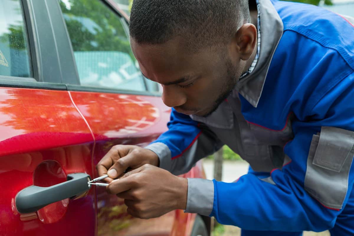 Mechanic holding lockpicker to open car door