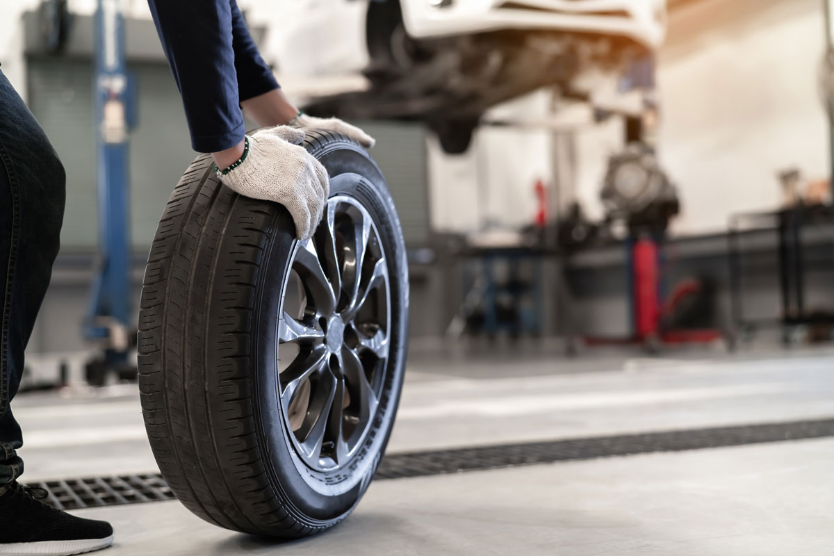 Mechanic man change a wheel tire and service maintenance the suspension of a vehicle