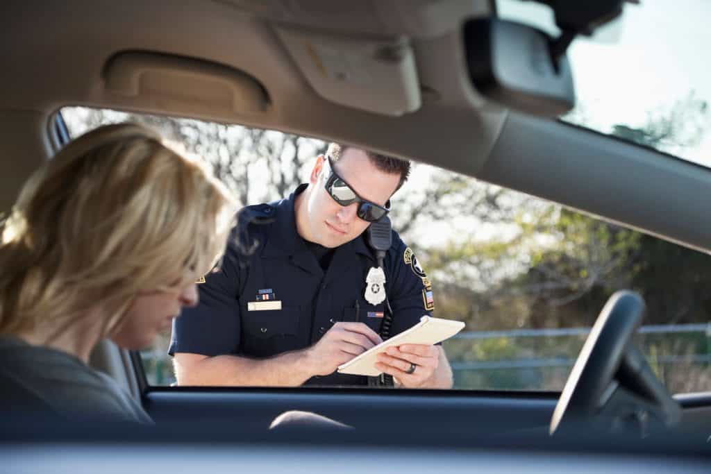 Police officer giving woman a traffic ticket.