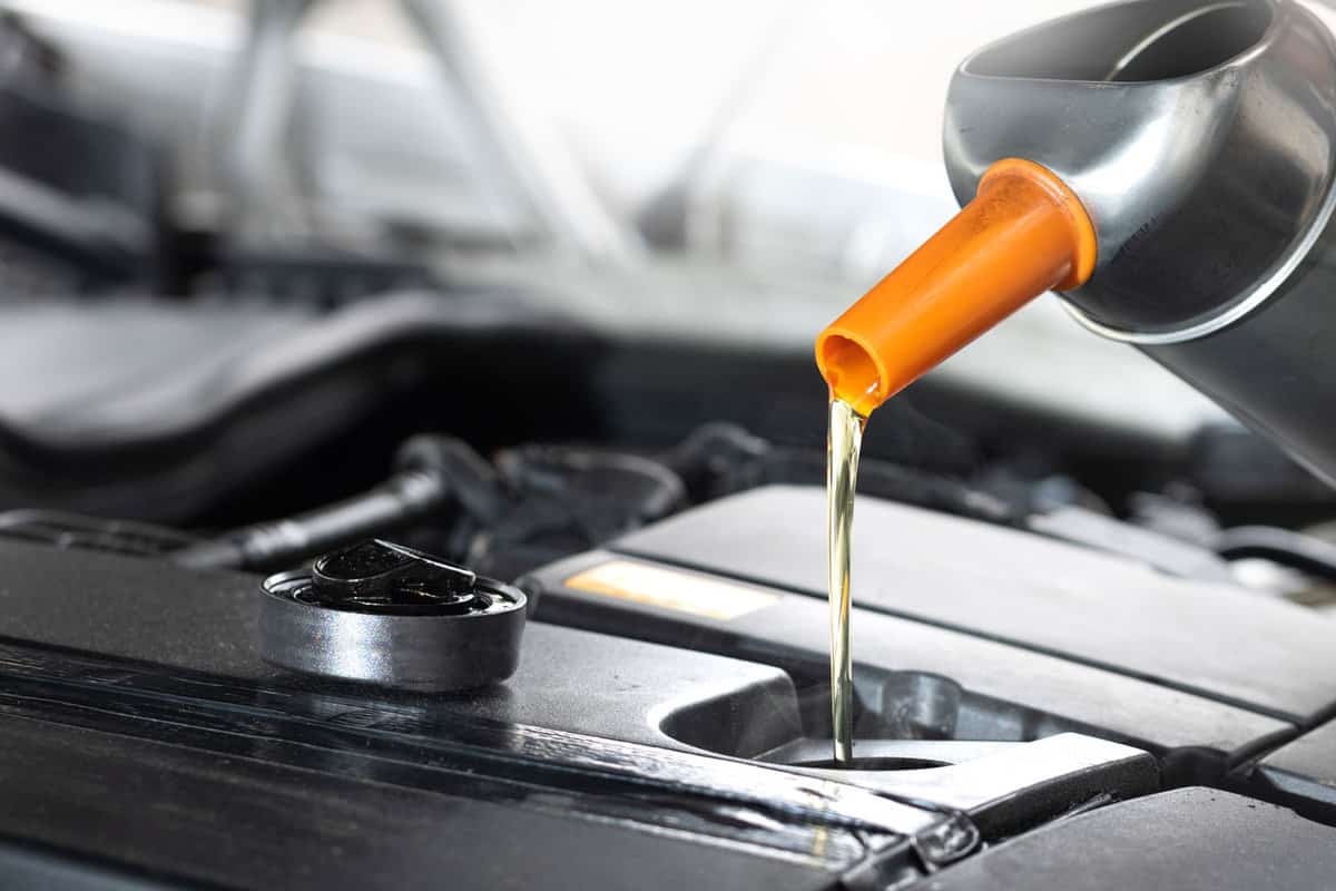 Pouring car oil in to the car engine