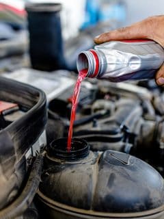 Pouring red colored car coolant to the coolant reservoir, Can Engine Coolant Freeze? [And At What Temperature]