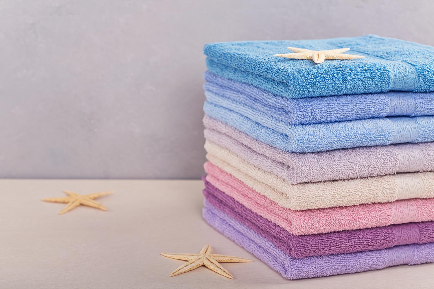 Stack of colorful bath towels on light background
