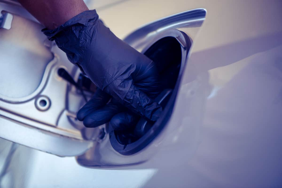 Woman wearing gloves opening the gas tank cover