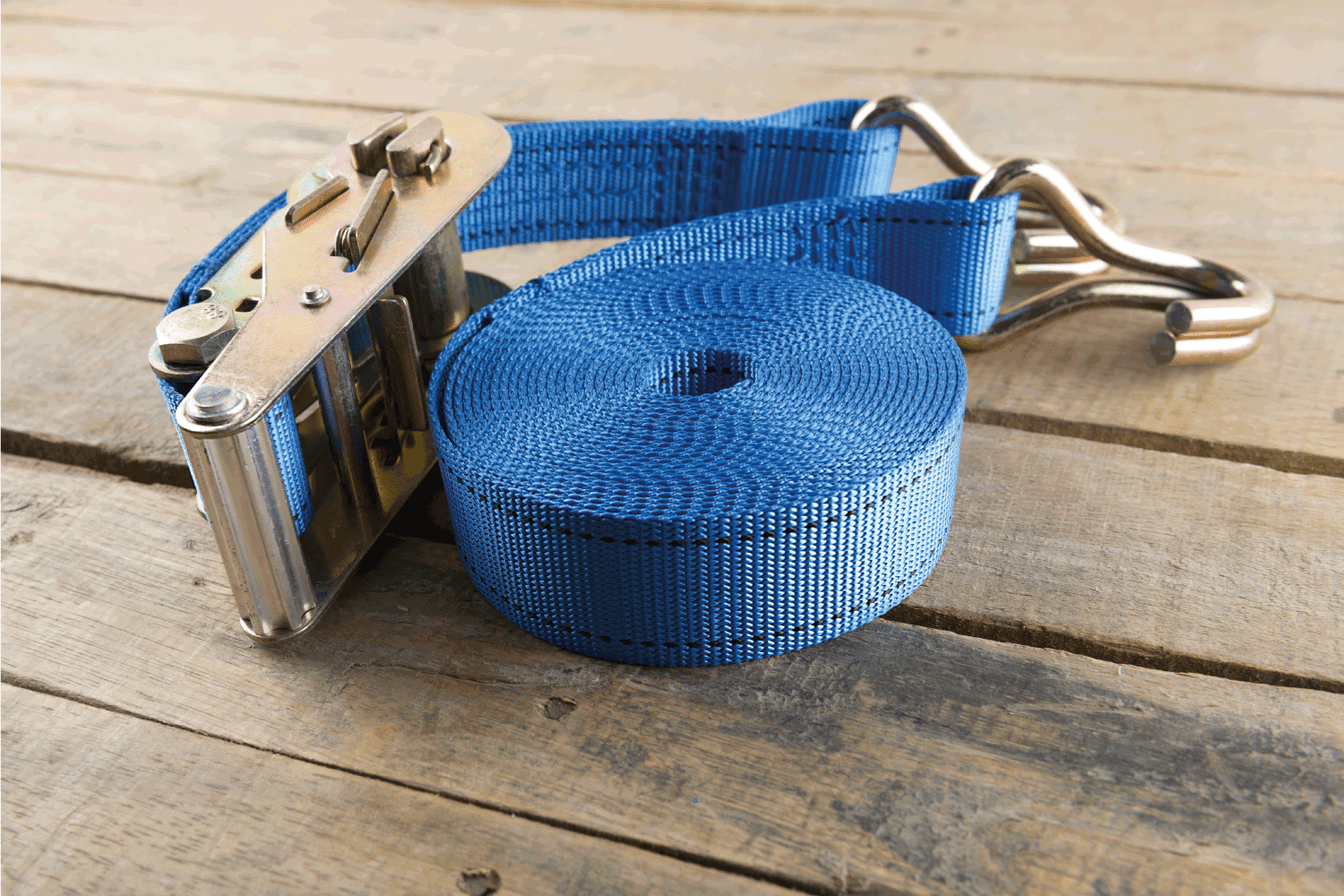 blue tie down strap ratchet on wood