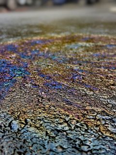 oil spill on asphalt road with rainbow reflection on it, What To Do If Gas Spills On Your Car
