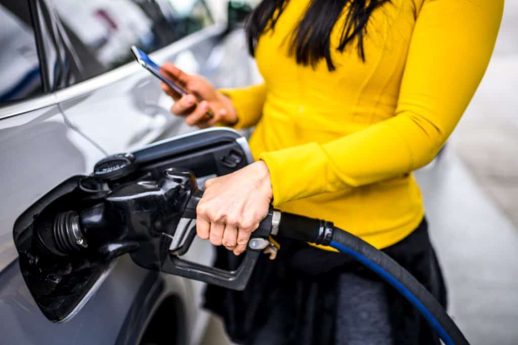 using a smart phone while refilling gas