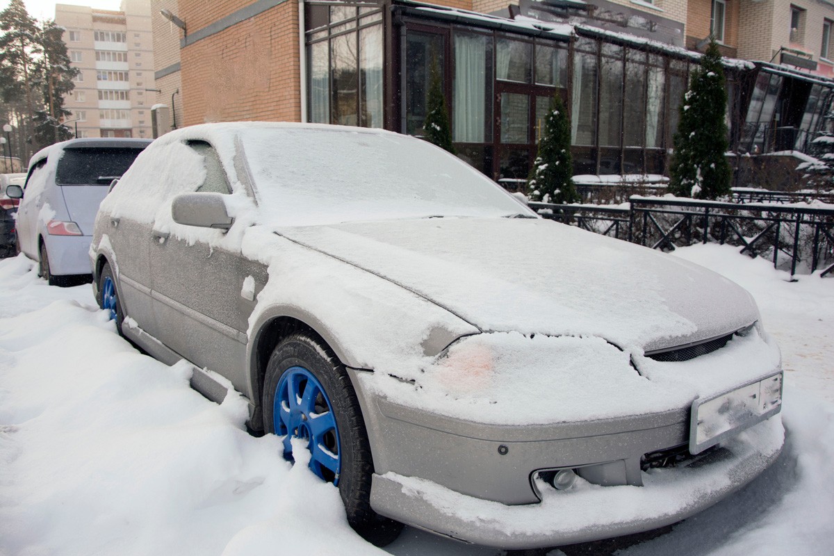 snow-covered car long standing on the street