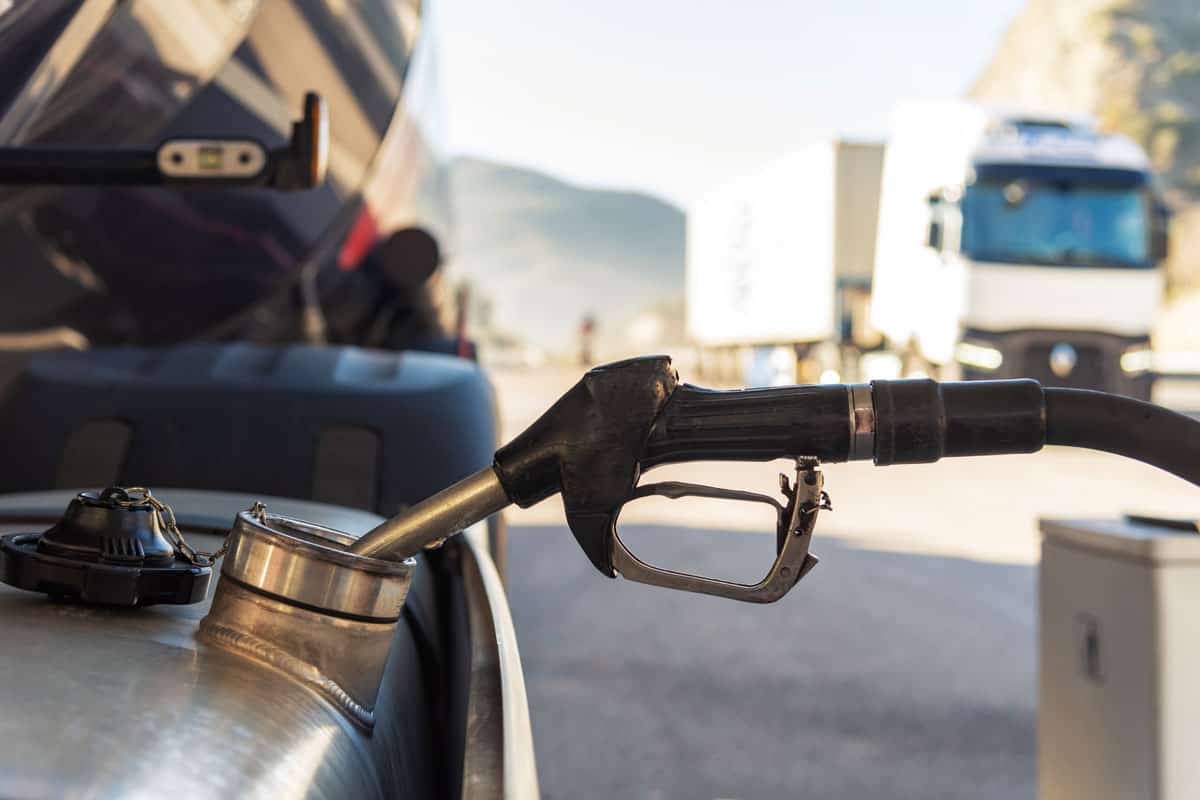 truck refueling diesel at a highway gas station, close-up of the nozzle inserted in the vehicle's tank