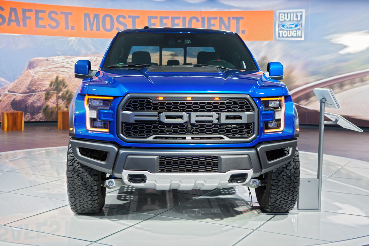 A blue Ford F150 Raptor at a Ford showroom