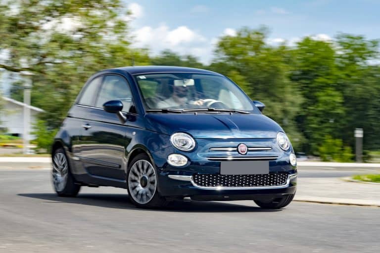 A blue colored Fiat 500 moving down the road, Can You Fit A Suitcase In A Fiat 500?