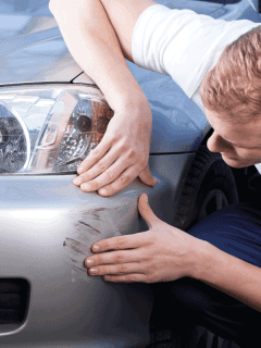 A man trying to fix a scratch on a car body. How To Remove Scuff Marks From Car