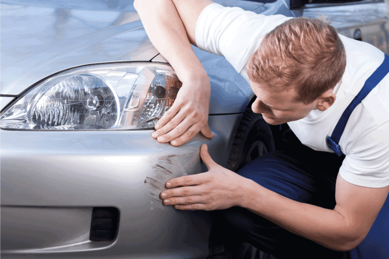 A man trying to fix a scratch on a car body. How To Remove Scuff Marks From Car