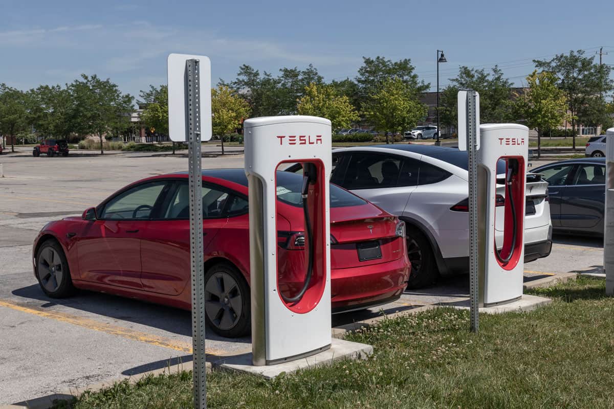 A red colored Tesla Model S at a charging station