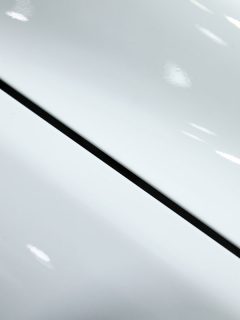 A white car hood photographed up close, Yellow Stains On White Car - What To Do?