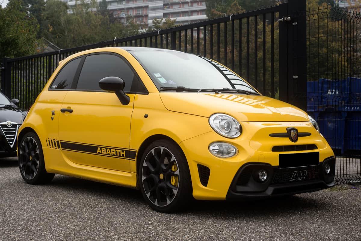 A yellow Abarth 500 parked on the side of the road