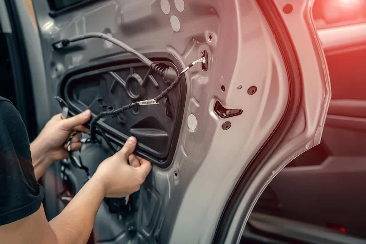 Auto service worker disassembles car door for repair
