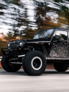 Black dirty Jeep Wrangler going fast on the road, Where to Place the Jack on a Jeep Wrangler