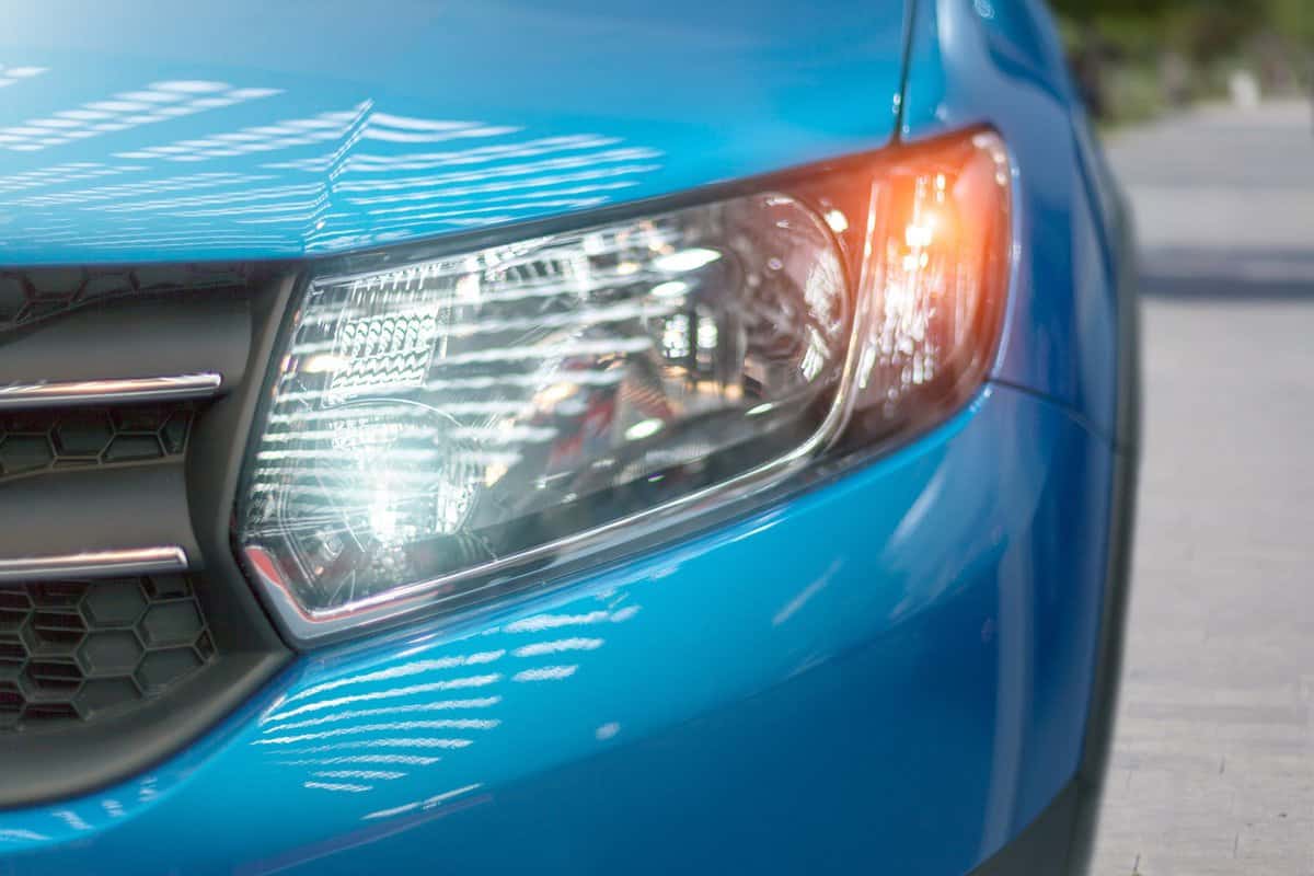 Blue modern car closeup of headlight. Exterior detail, shallow depth of field.