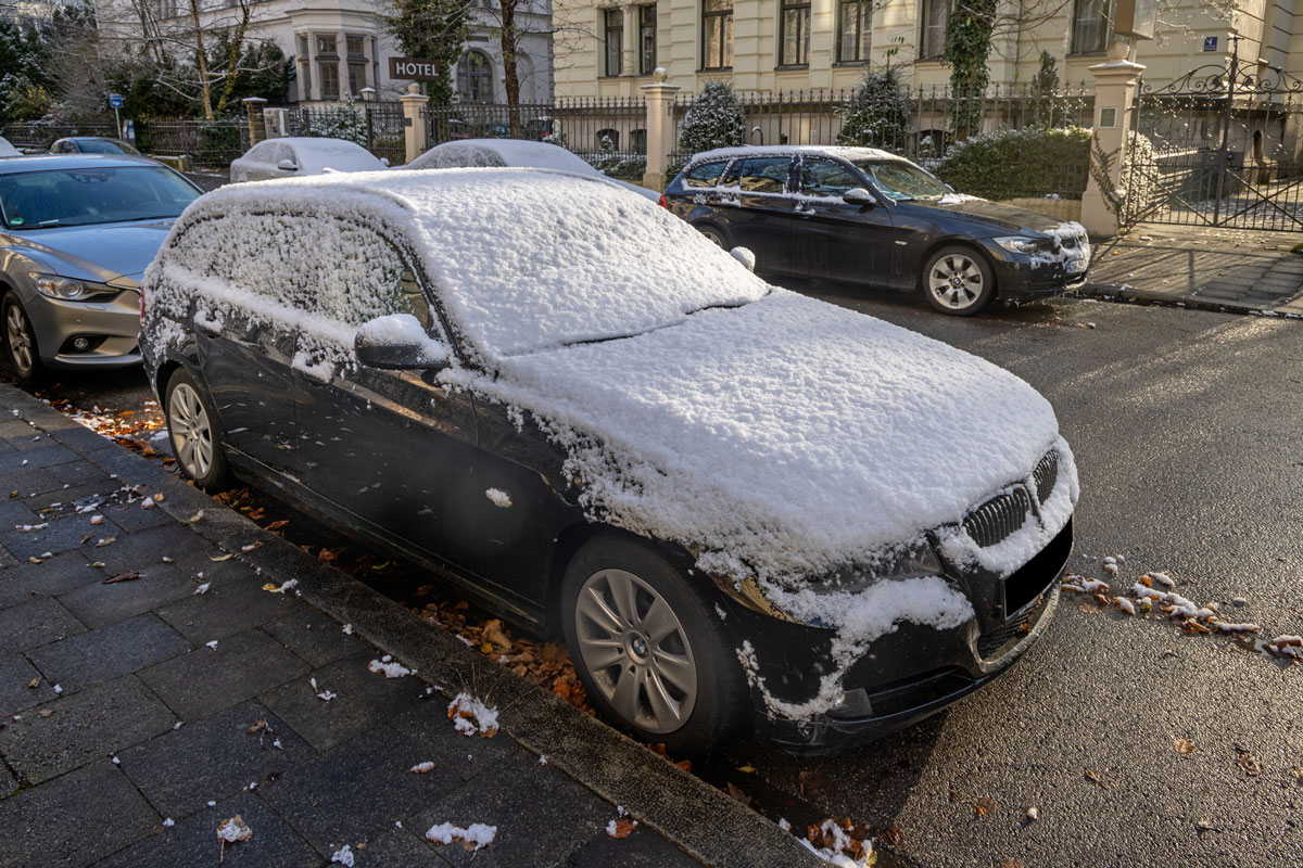 Car covered in light snow on a winter morning